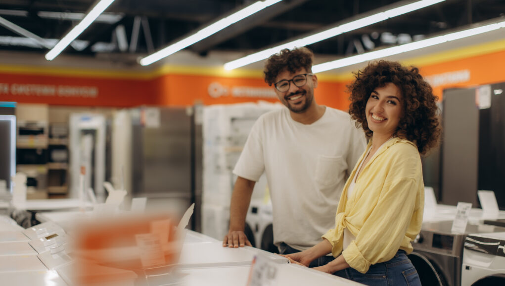 Happy Couple Smiling While Shopping at an Electronics Store